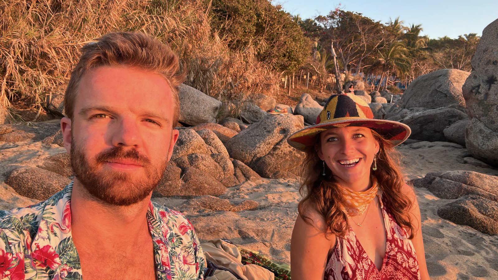Two guests on the rocks at the beach in the last light