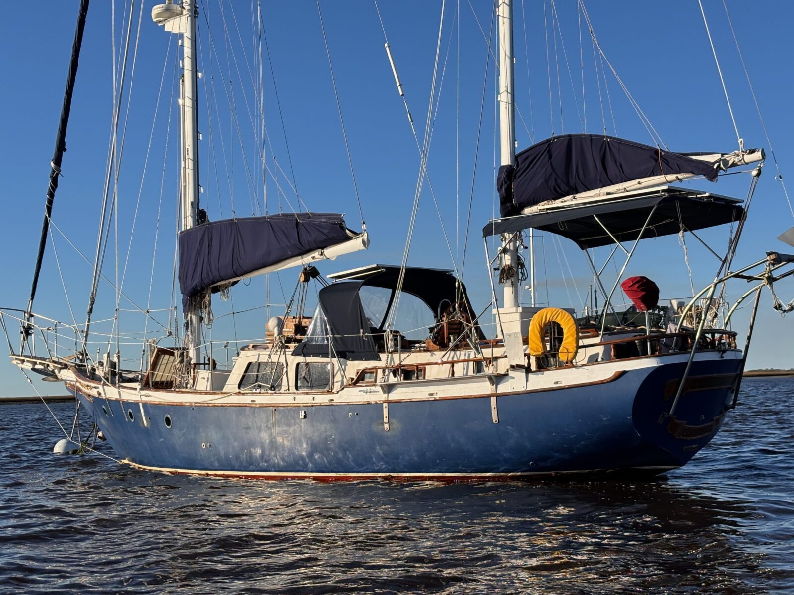 Starchaser from the side, a blue-hulled ketch with two masts