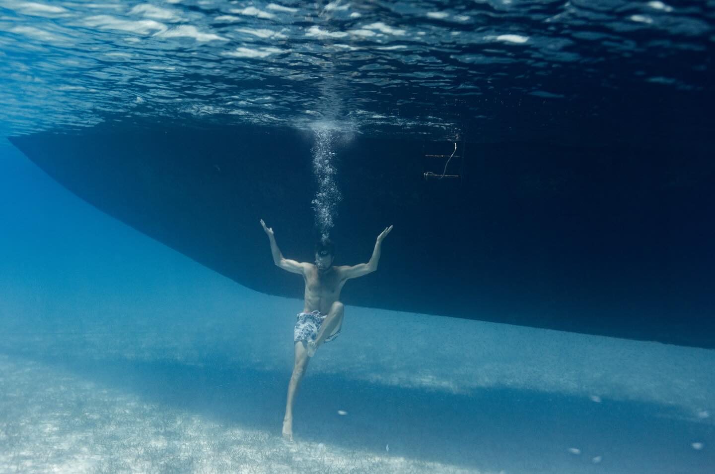 A swimmer under Starchaser’s hull in clear blue water